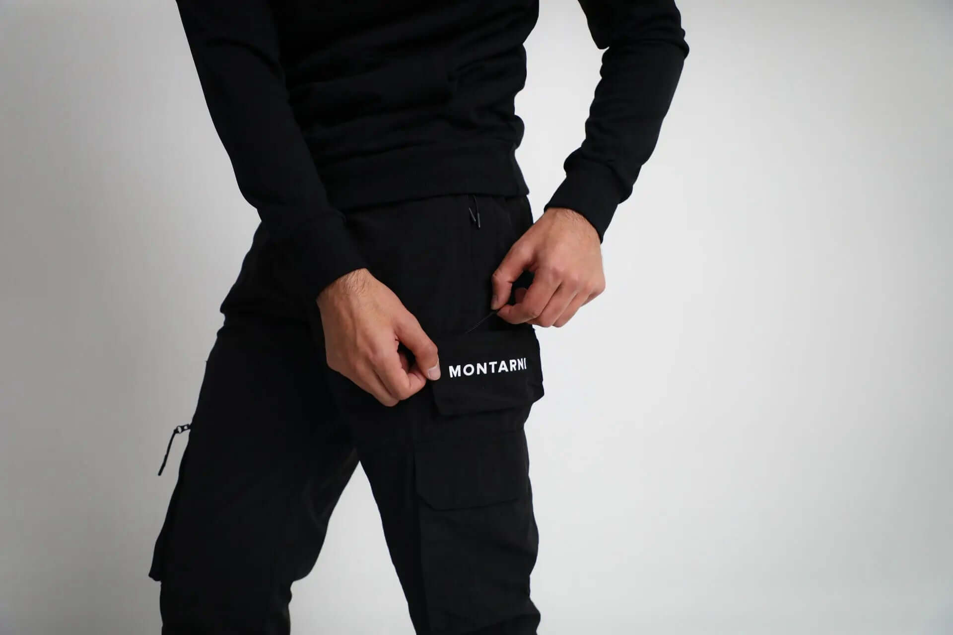 Side view of Montarni casual Cargo pants men showing zip pocket and flap pocket on thigh in light black fabric