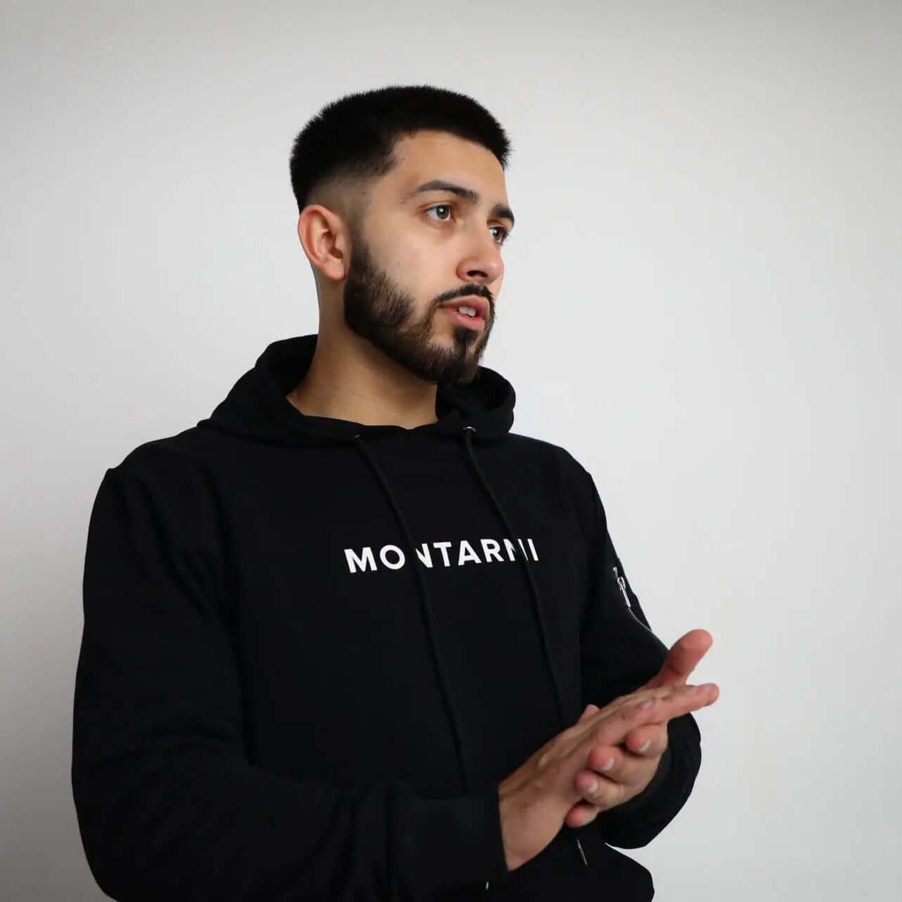 Techwear hoodie featuring Montarni logo, worn by model in black hoodie, showcasing stylish and modern design.