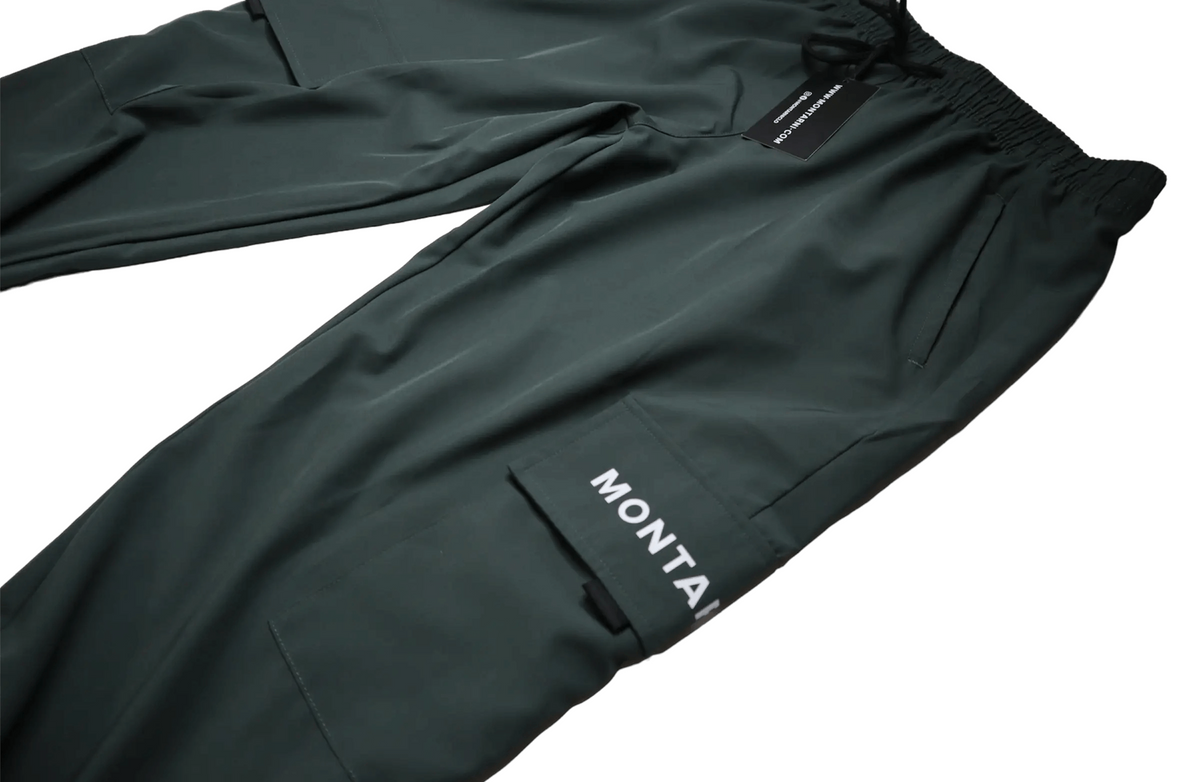 Utility streetwear cargo pants for men showing a sleek dark green design with side pockets and modern branding.