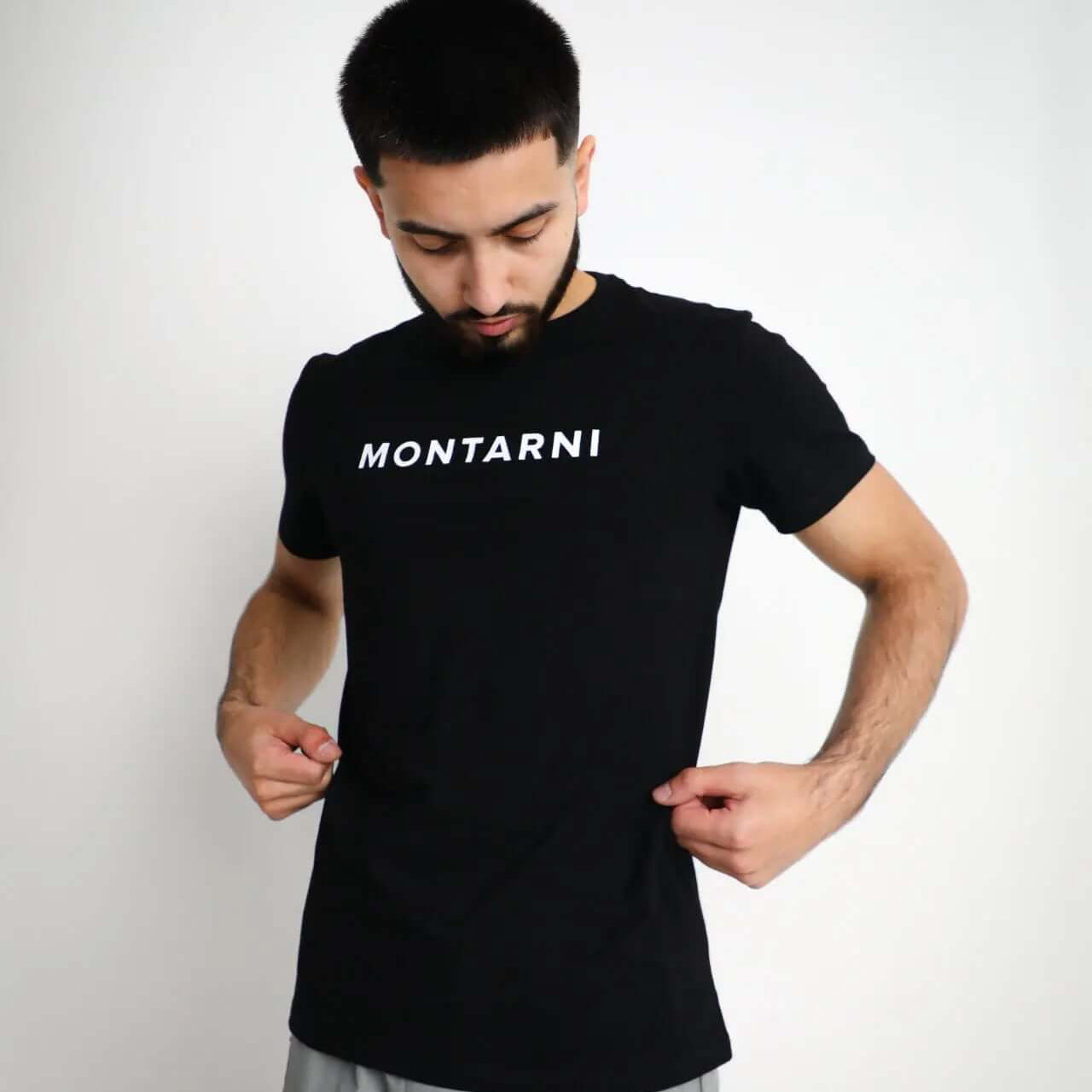 Young man wearing a Slim Fit Cotton Stretch T-Shirt with Montarni branding, styled in a modern, casual outfit.