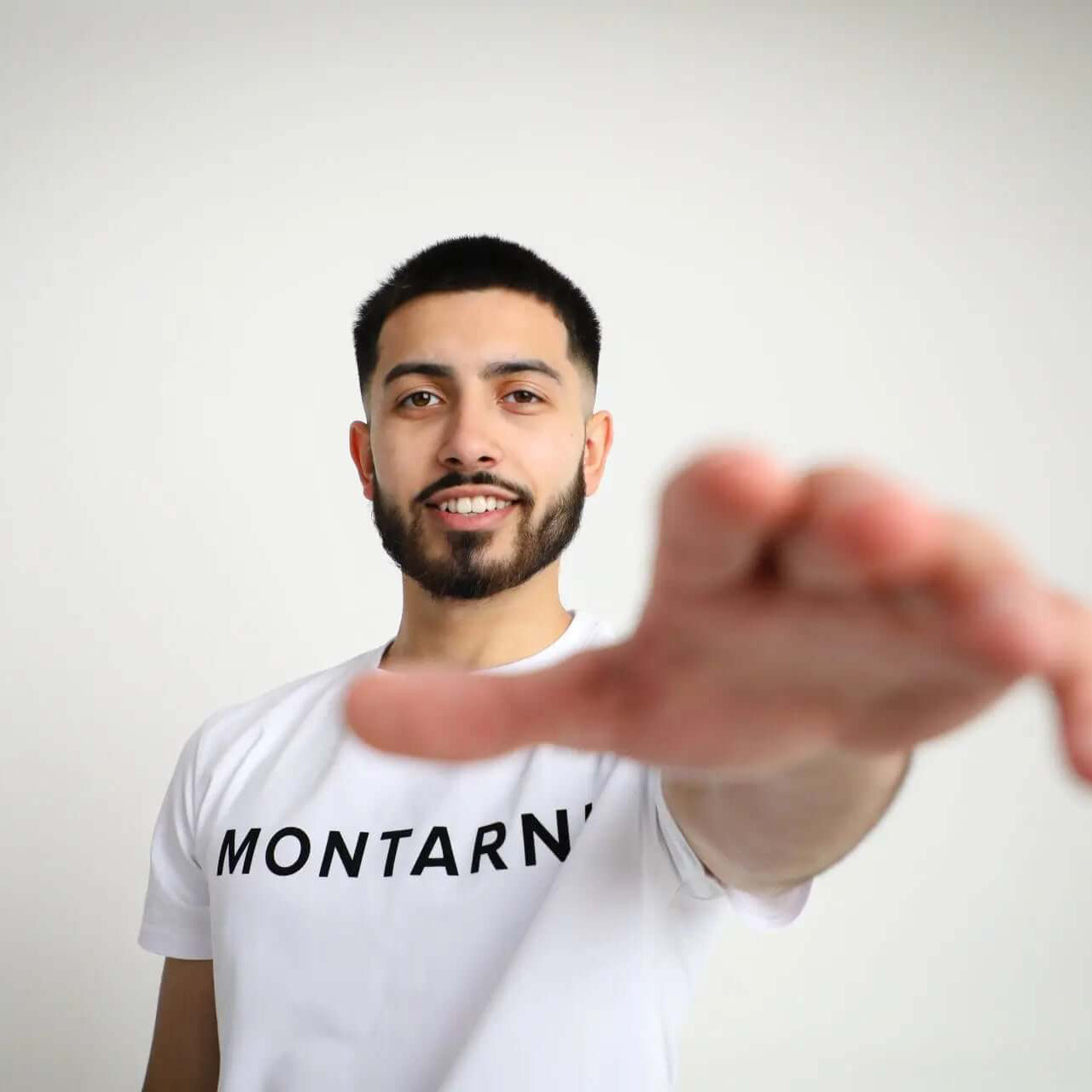 Model wearing a Slim Fit Cotton Stretch T-Shirt with Montarni branding, posing confidently with hand extended.